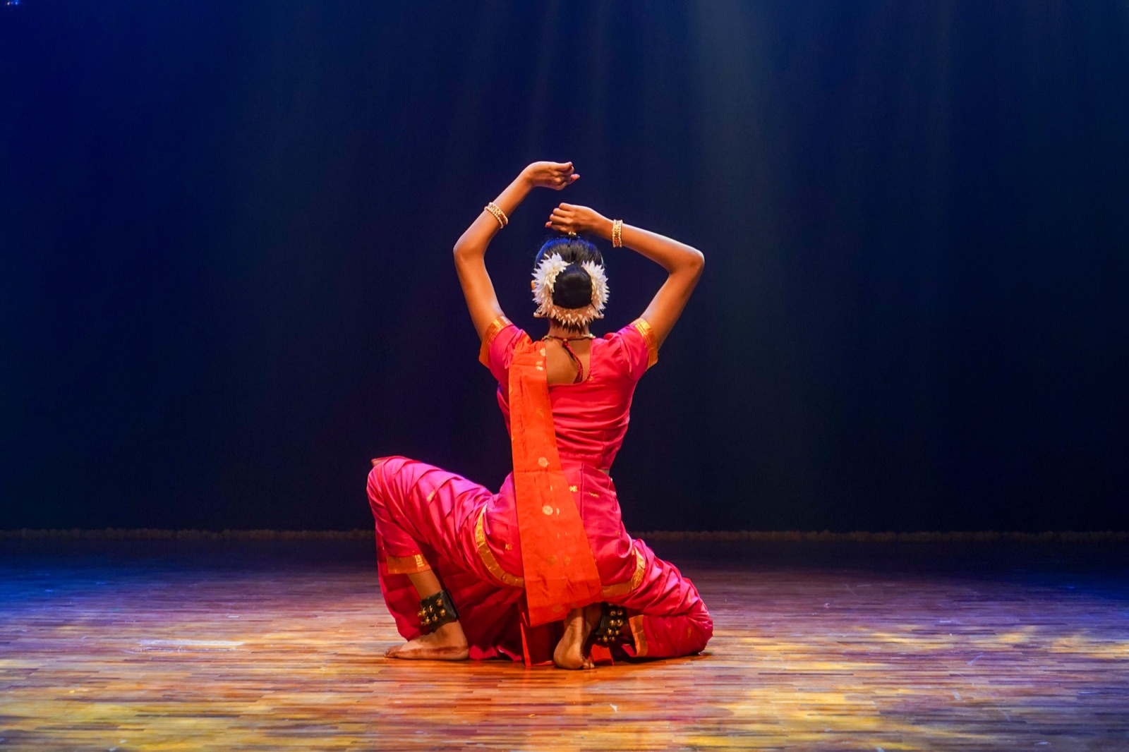 A classical Indian dancer mid-performance in ornate costume